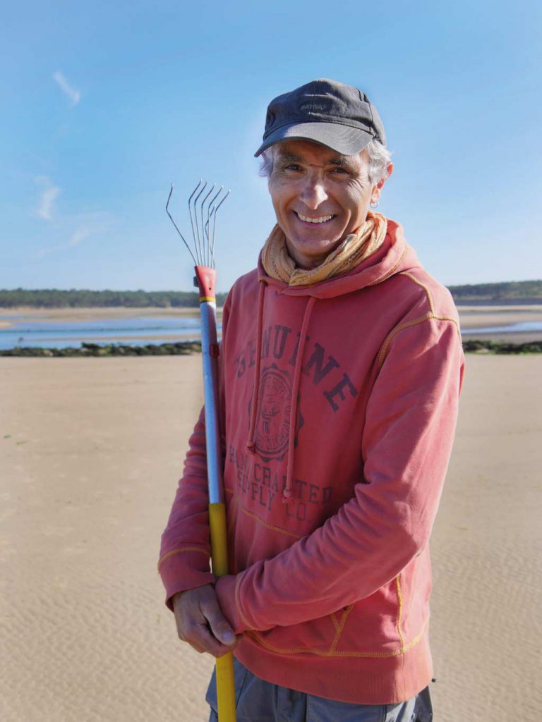 Avec son râteau, le jeune beach artiste dessine le sable sur les plages de  Saint-Brevin